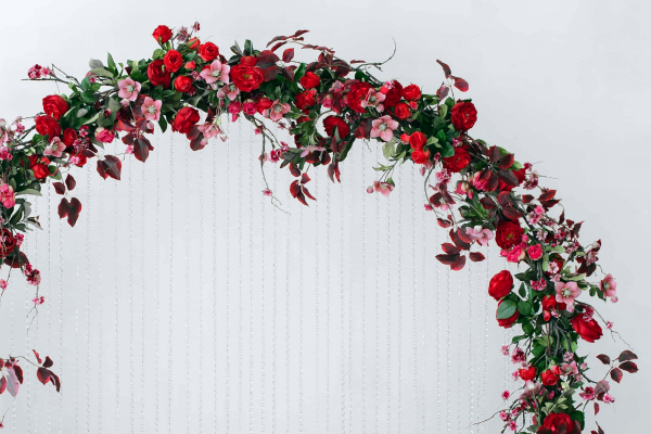 Фотозона с красной цветочной аркой
